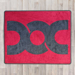 Large rectangular floor rug with Dubbed Out Community logo on shown in red carpet with grey carpet logo