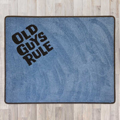 Large rectangular floor rug with Old Guys Rule logo shown in grey carpet with black carpet logo