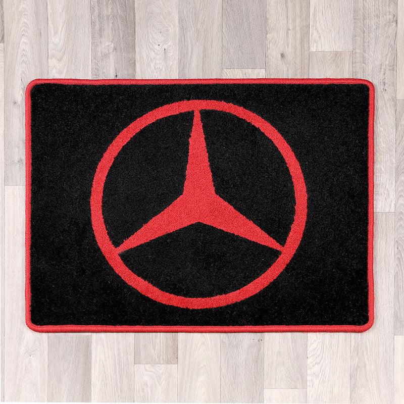 rectangular black and red rug with Mercedes logo in the middle